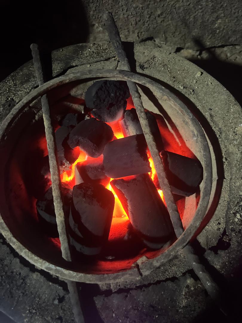 Close-up of briquettes burning intensely in a metal cooking stove